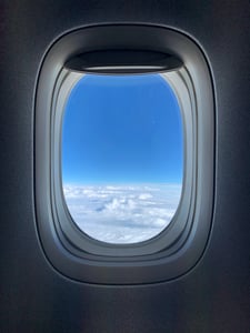 Airplane window looking at clouds