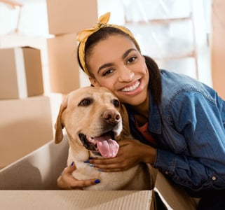 Woman with yellow lab and moving boxes