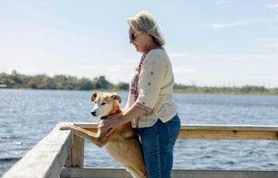 Dog and owner looking over a body of water in Australia.