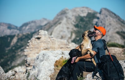 Man with two dogs in the hills of Italy after traveling around the world.