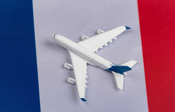 Toy airplane sitting on top of a French flag.