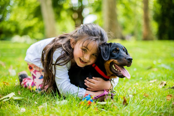 little girl hugging dog