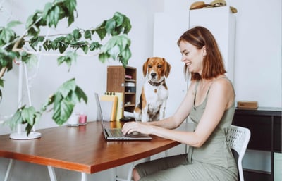 Woman and her dog working on a laptop.