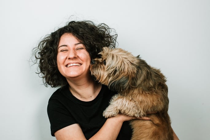 woman hugging small dog