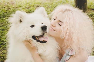 global pet travel costsWoman hugging white fluffy dog