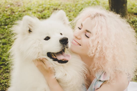 woman hugging white dog